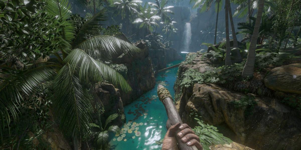 Um jogador segurando uma lança olhando para uma cachoeira no Green Hell