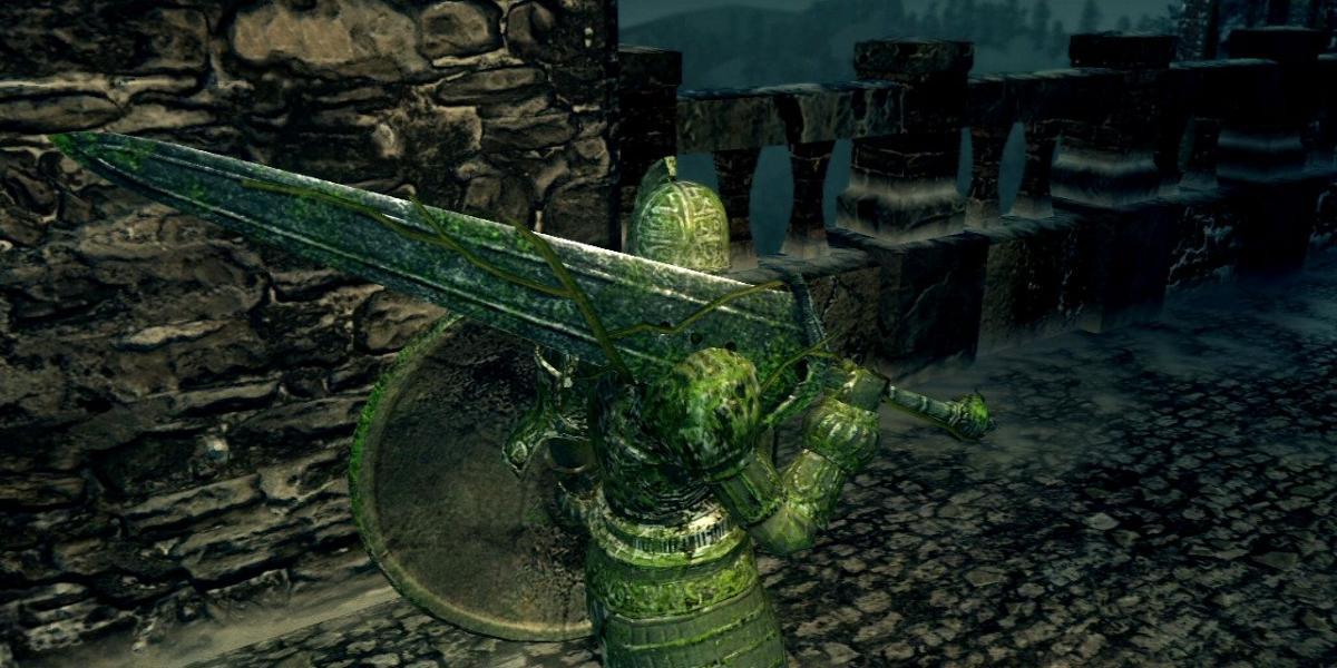 jogador em armadura de cavaleiro de pedra empunhando a grande espada de pedra na área urbana de dark souls