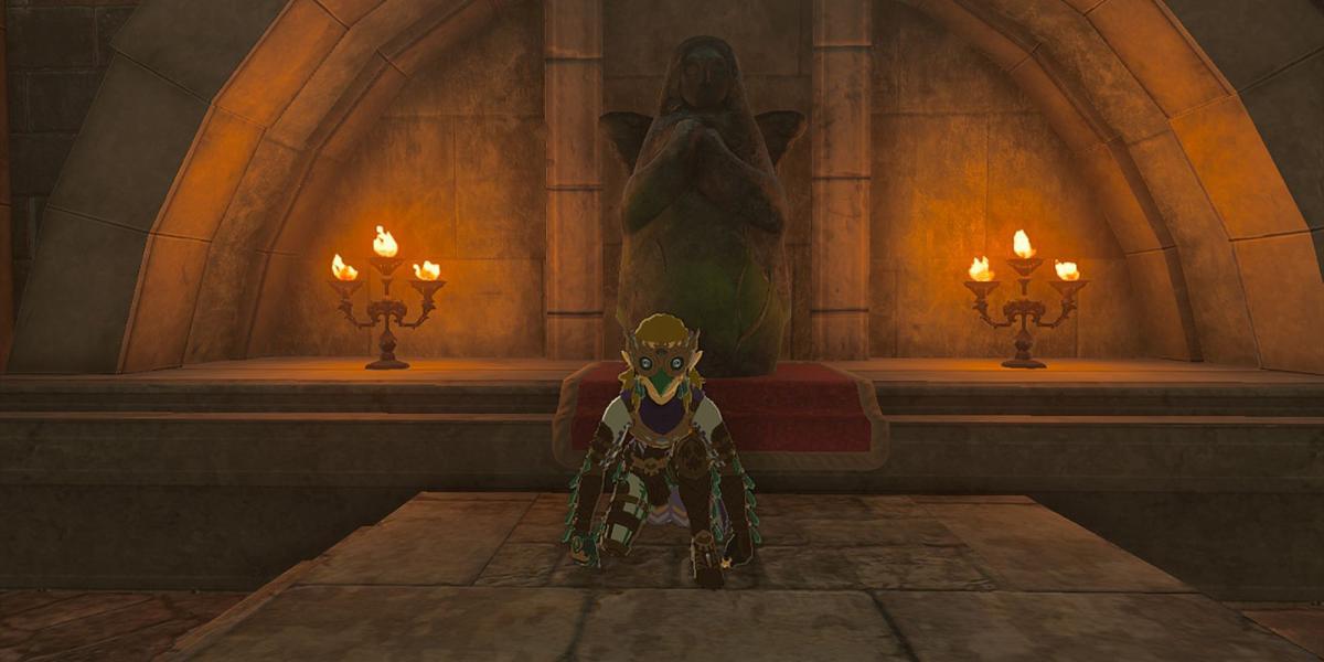 Zelda Tears of the Kingdom - Link agachado em frente à estátua da deusa do pouso do abrigo de emergência