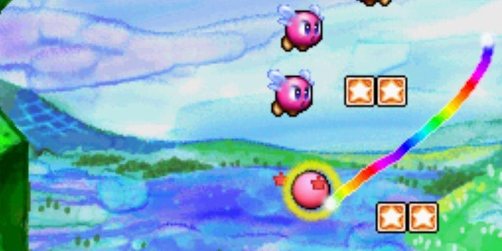 Uma linha de arco-íris que a bola de Kirby está seguindo enquanto os inimigos voam nas proximidades em Kirby Canvas Curse