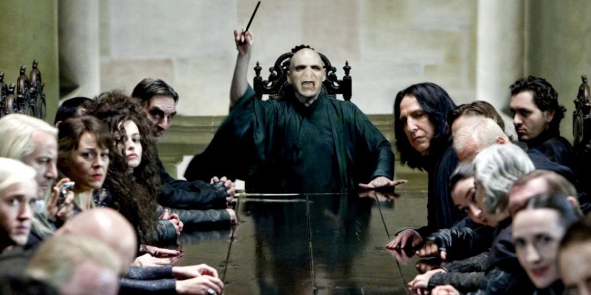 Voldemort em uma mesa com Comensais da Morte em Harry Potter