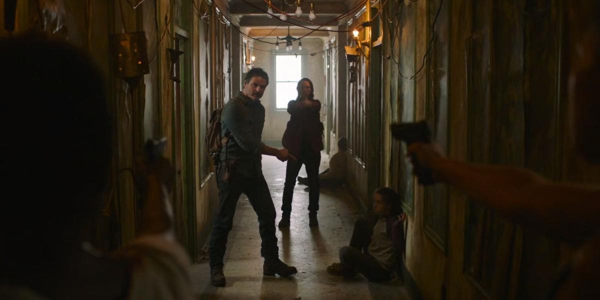 Joel, Tess e Ellie em um corredor em The Last of Us.