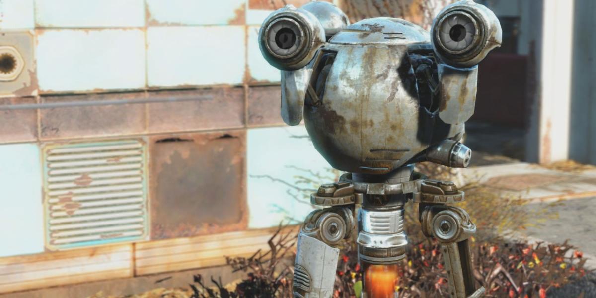 O droide Codsworth de Fallout está sujo e enferrujado. Ao fundo, há uma parede de painéis que está enferrujada e alguns arbustos mortos