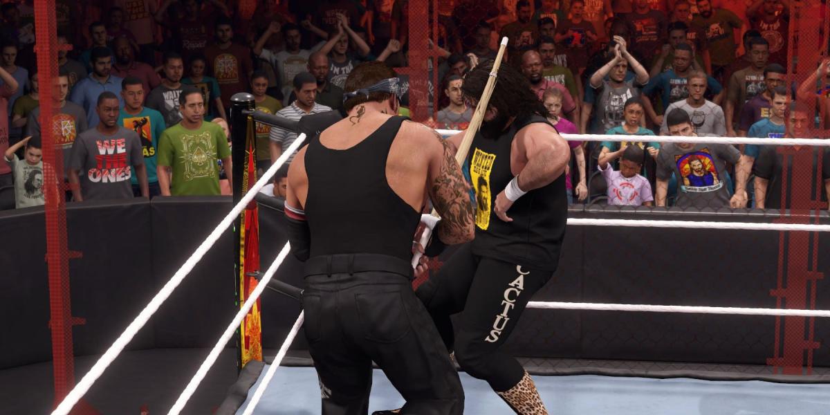 WWE2K23 Undertaker atacando Cactus com um bastão de Kendo