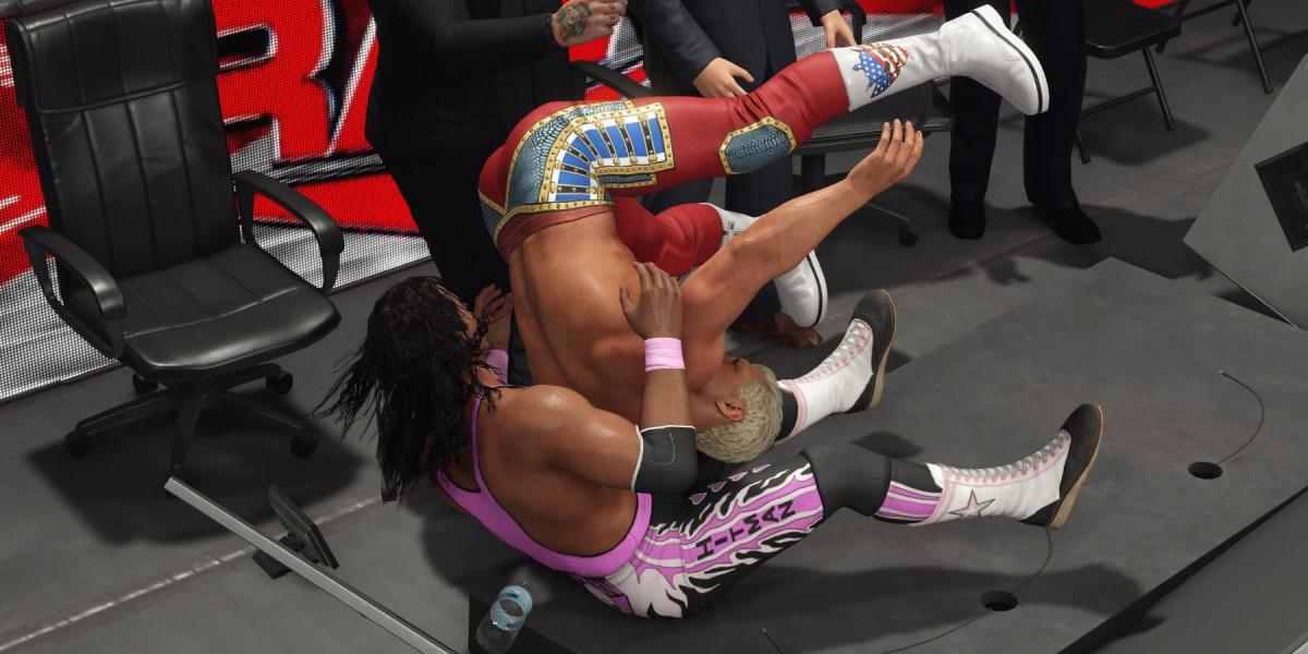 WWE 2K23 Bret Hart acertando Cody com o Finisher através da mesa do locutor