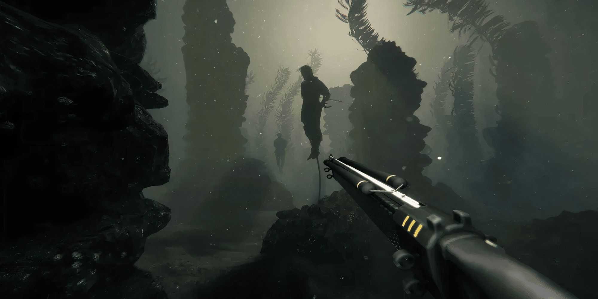 Holding a weapon underwater while looking at a captive person.