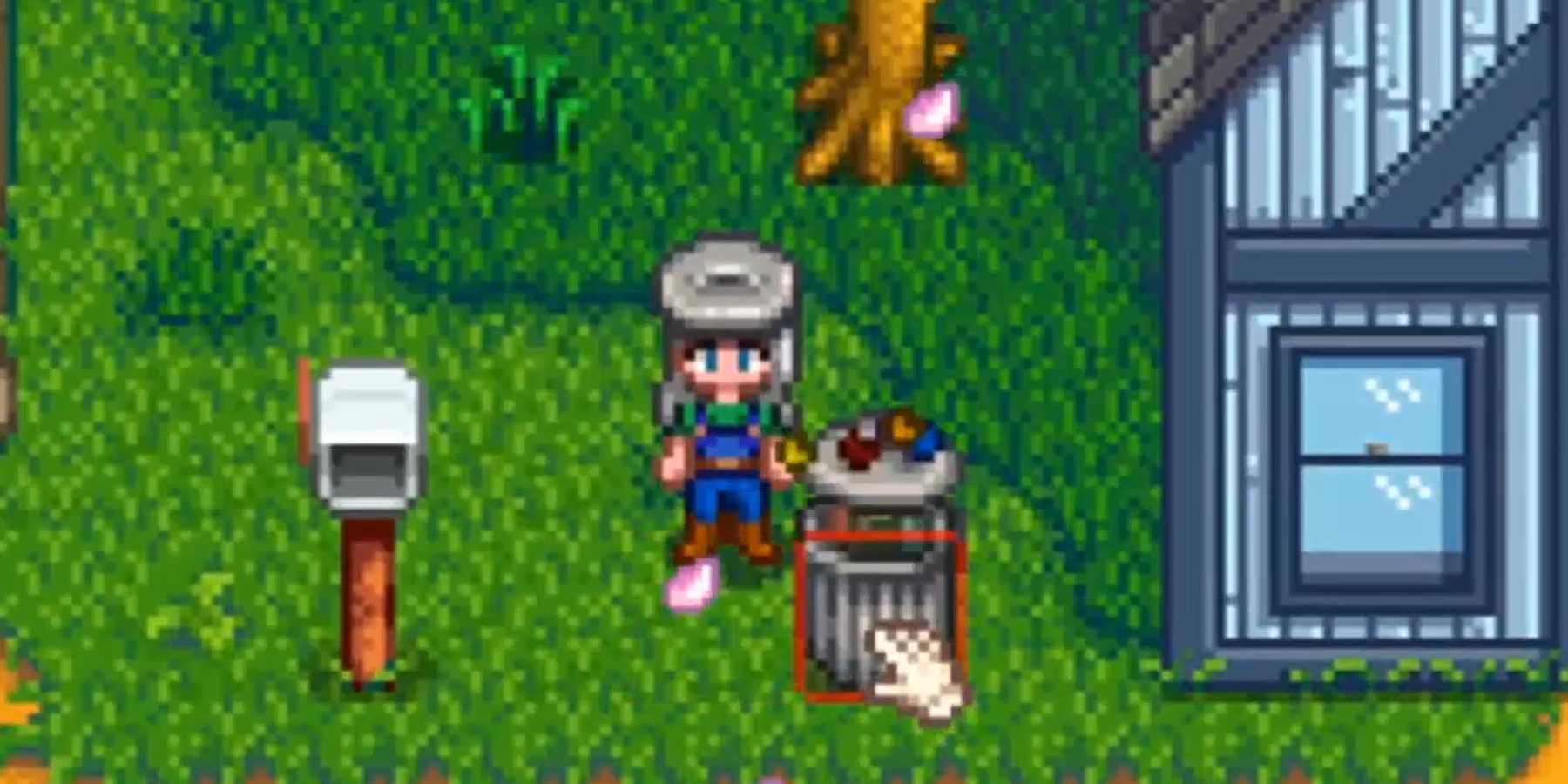 Personagem de Stardew Valley em pé ao lado de uma lata de lixo usando um chapéu de lixo