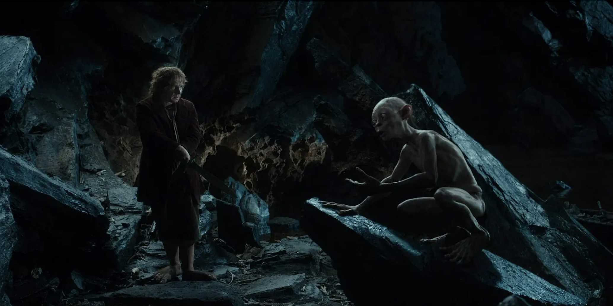 Bilbo in a cave with Gollum perched on a rock from The Hobbit