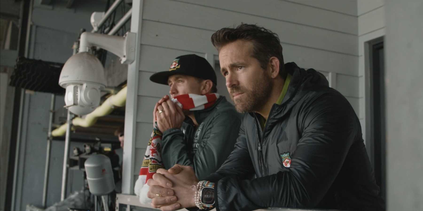 Ryan Reynolds e Rob McElhenney olhando das arquibancadas de Wrexham