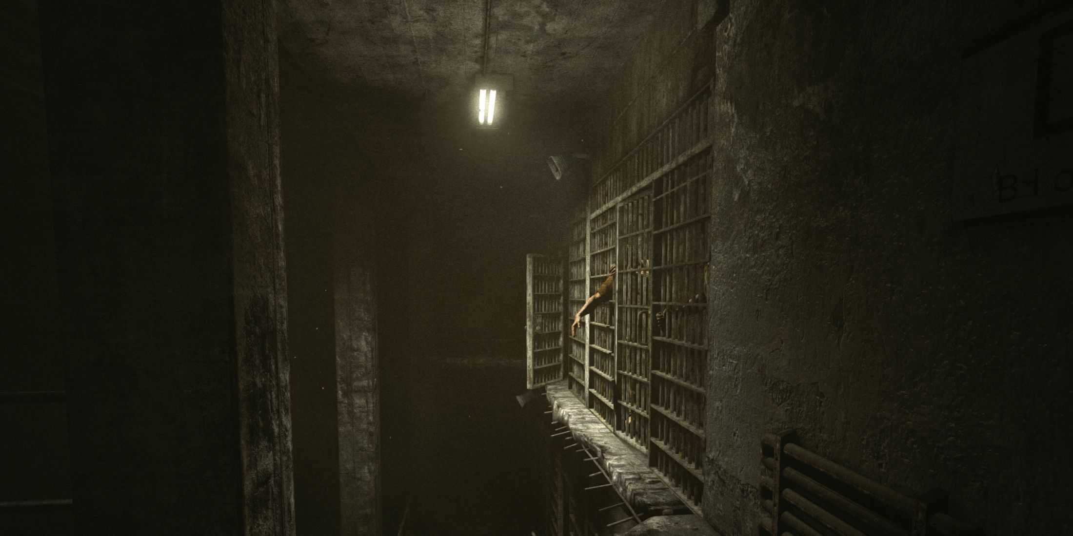 A hand sticking out of prison cell bars in a long corridor