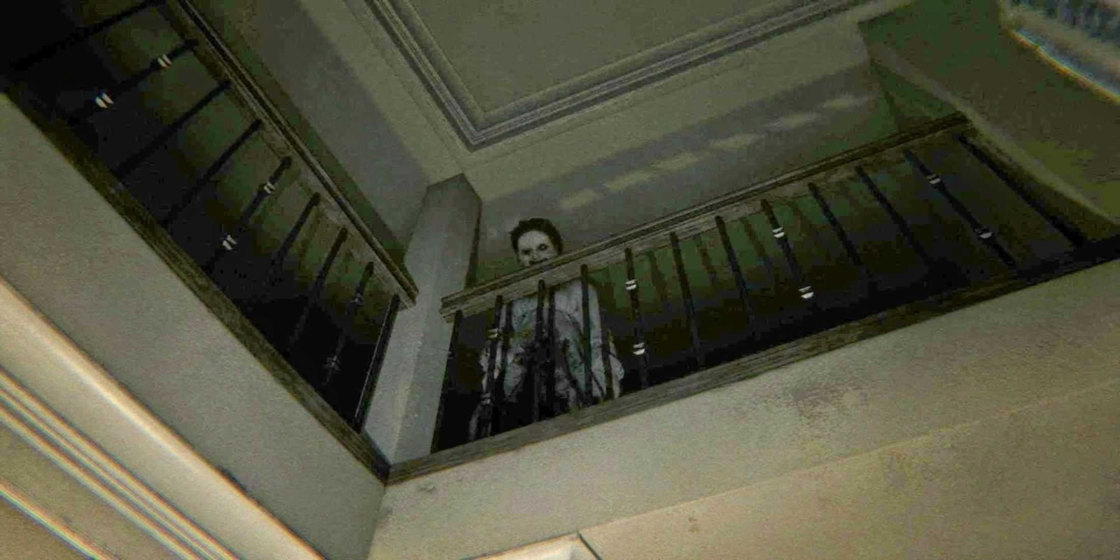 A scary figure standing on the upper level of a house and overlooking a balcony