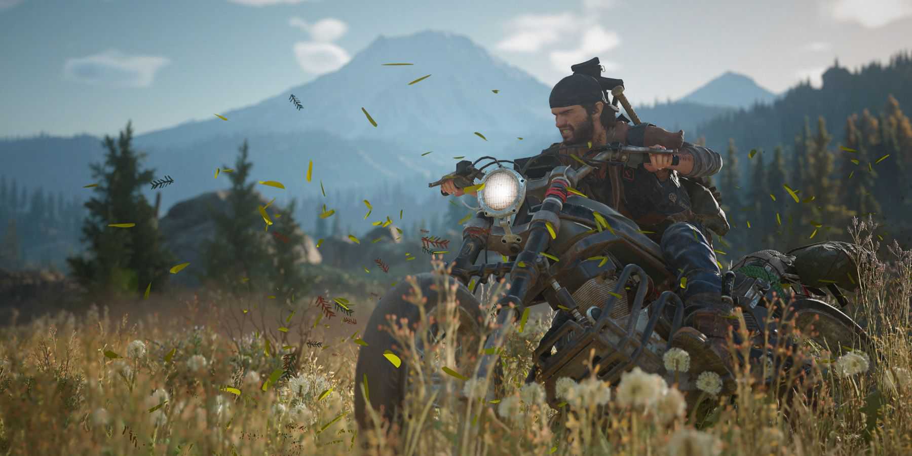 Captura de tela da cena de Days Gone Deacon St John dirigindo uma bicicleta pelo campo de dente-de-leão